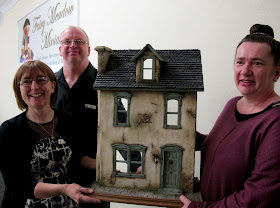 The owners of Fairy Meadow Miniatures shop presenting the prize house to the winner of the VIP opening raffle.