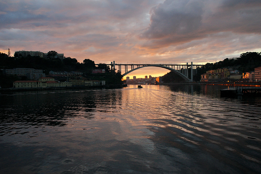Ponte vista de Massarelos Vista sobre a ponte, ao fim da tarde, com o primeiro plano preenchido pelo rio e reflexos do poente. Ao fundo um Barco Rabelo a passar por debaixo da ponte