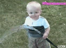 cute kid trying to drink water through rubber pipe