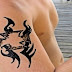 Black tribal ribbon tattoo on arm
