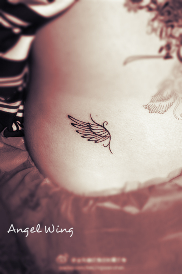 a very concise and elegant angel wing tattoo on the hip