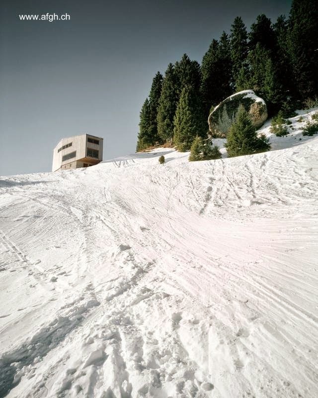 Una perspectiva a cierta distancia del moderno volumen geométrico Moderno chalet de montaña en Suiza