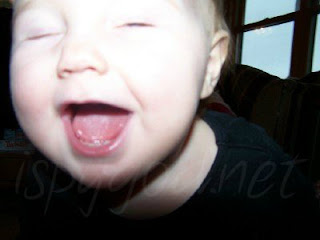 face of 1 year old child, eyes closed and laughing