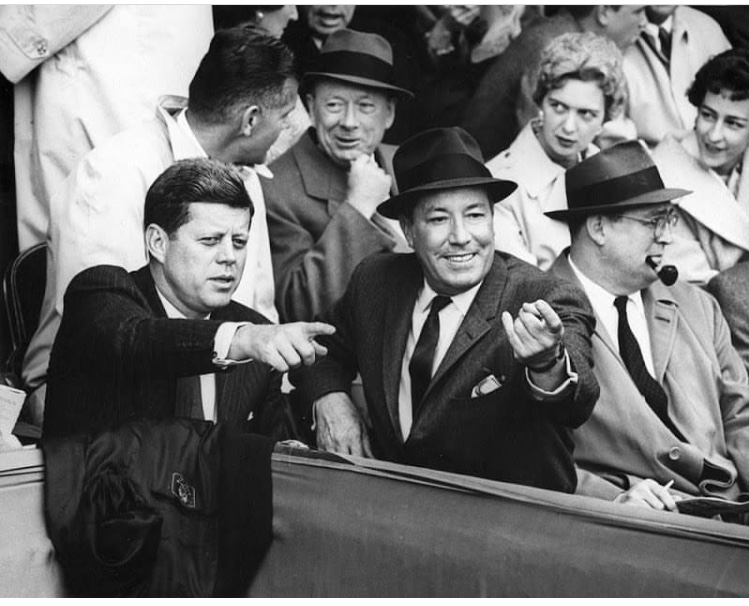 Secret Service agent Jerry Behn behind JFK having a chat with a gentleman as 2 ladies check him out