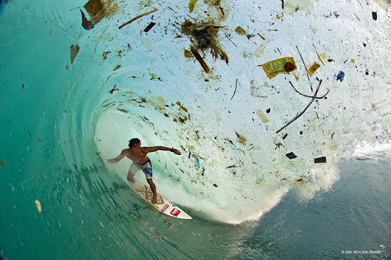 surfista de indonesia deslizándose en ola llena de basura