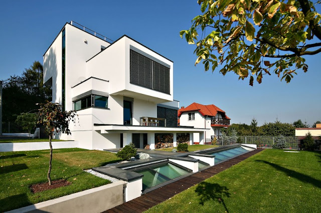 Vast Green Grass Garden and White Colored Wall which is Made from Concrete