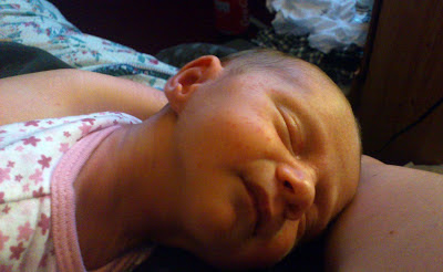 premature baby sleeps on mother's arm