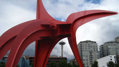 Red Alexander Calder steel sculpture with Seattle's Space Needle straddled between the legs