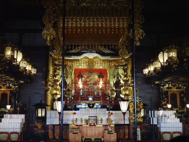 The visitors bow and pray in front of the Asakusa Shrine at the main temple's hall of Asakusa Sensoji Kannon Temple in Tokyo, Japan The visitors bow and pray in front of the Asakusa Shrine at the main temple's hall of Asakusa Sensoji Kannon Temple in Tokyo, Japan