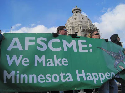 Several people holding a green AFSCME banner
