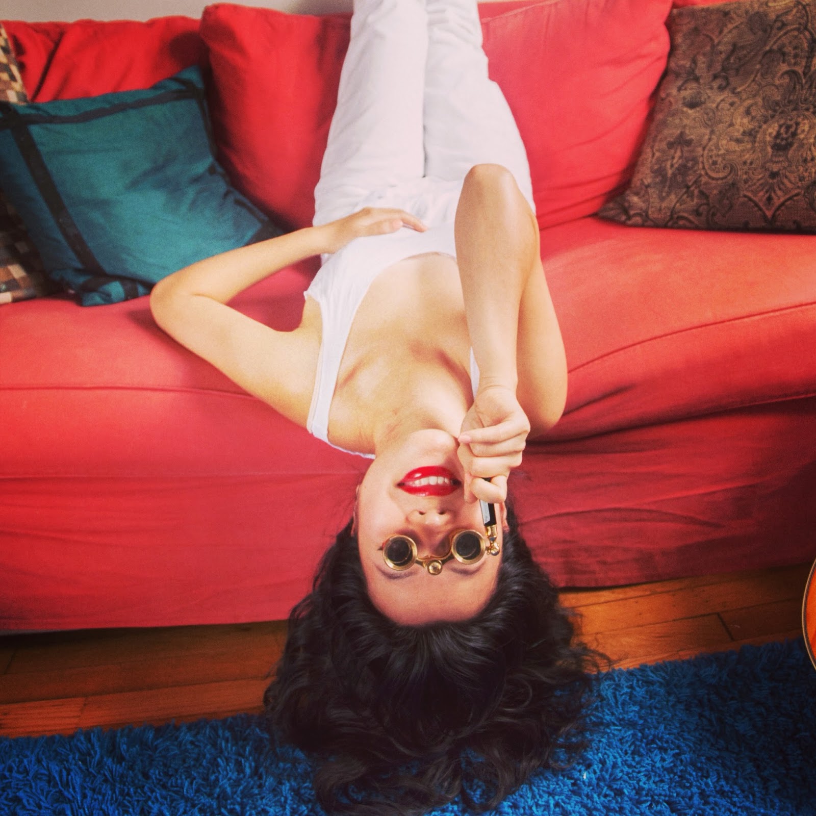 red lips white pants white tank red couch blue carpet opera glasses cushions