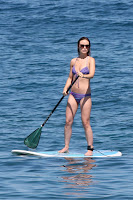 Olivia Wilde standing on a paddle board wearing a tiny bikini