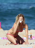 Samara Weaving in a bikini on the beach having a drink