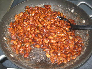 Almonds in a pan on a stove with sugar and cinnamon mixed in