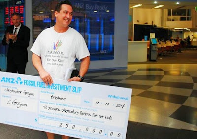 Man with a large novelty cheque to celebrate his divestment from banks investing in fossil fuels