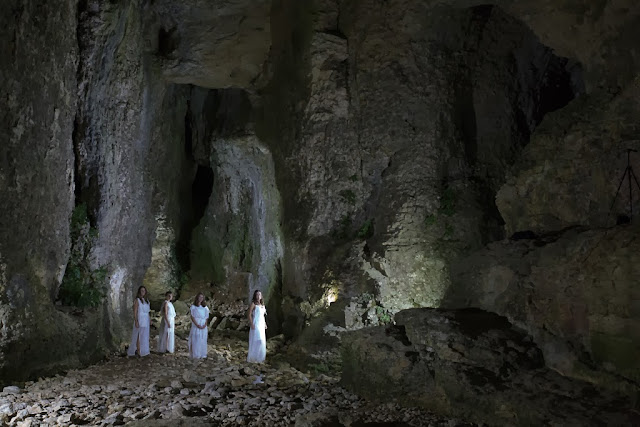 quattro fanciulle davanti l'ingresso della grotta