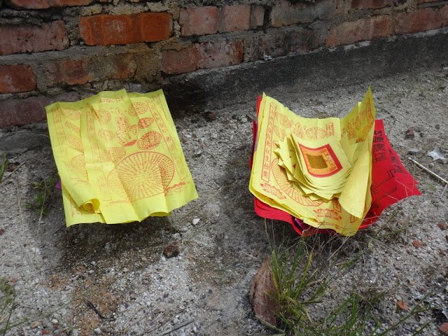 Some of joss paper are arranged accordingly and ready to be burned as an offering to ancestors or the loved ones in front of their tombs at Chinese cemetery in Malaysia Some of joss paper are arranged accordingly and ready to be burned as an offering to ancestors or the loved ones in front of their tombs at Chinese cemetery in Malaysia