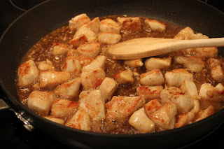 adding sesame sauce to chicken in skillet