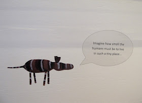Wall sign in a gallery that reads 'Imagine how small the humans must be to live in such a tiny place'.