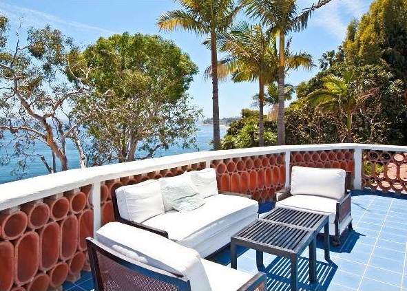 patio with blue tile floor and wooden arm chairs and sofa with white cushions