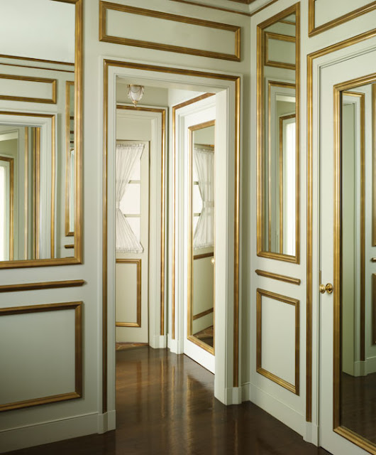  hallway of doors and mirrors with mint walls and gold decorative molding