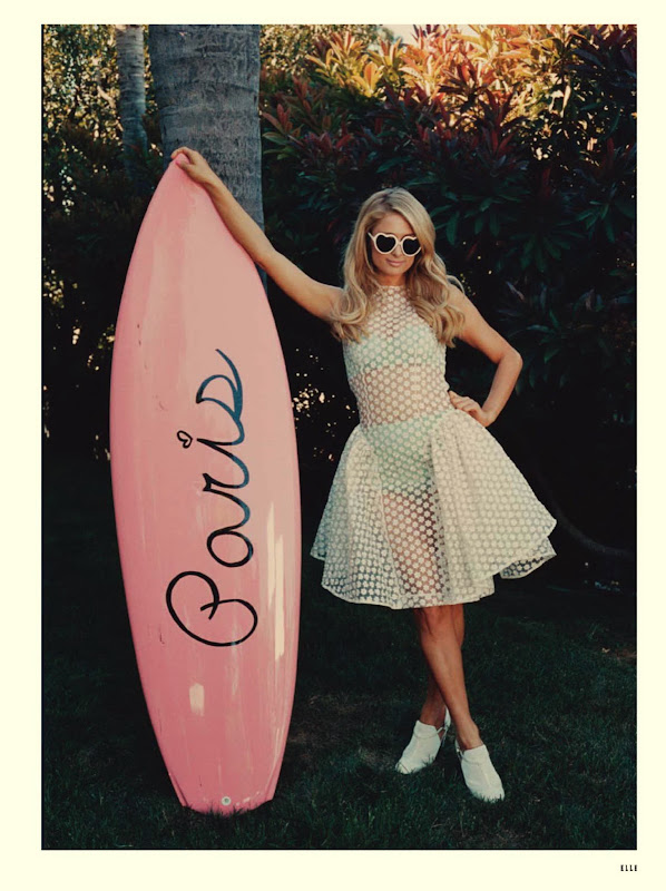 Paris Hilton in a see through dress holding a pink surf board