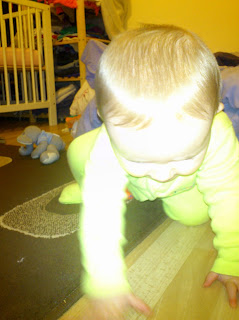 baby in green onesie crawling