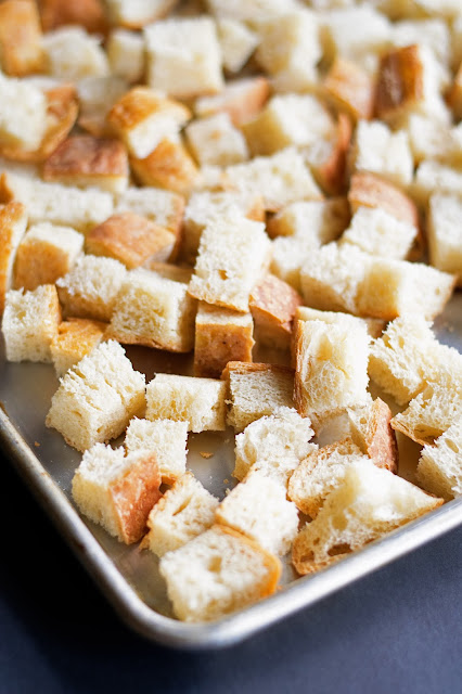 The homemade bread cubes on a baking sheet. 