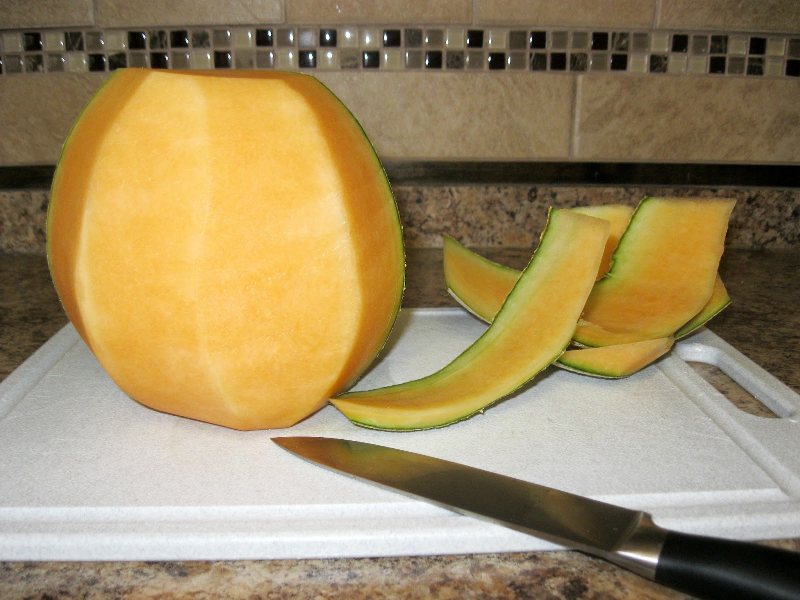Stand the Cantaloupe up on one of the flat ends and slice down the middle.