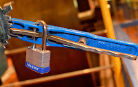 Lock No Key, copyright 2013, Stephanie Maatta Smith master brand padlock on a blue machine gear, The Henry Ford, Dearborn, Michigan