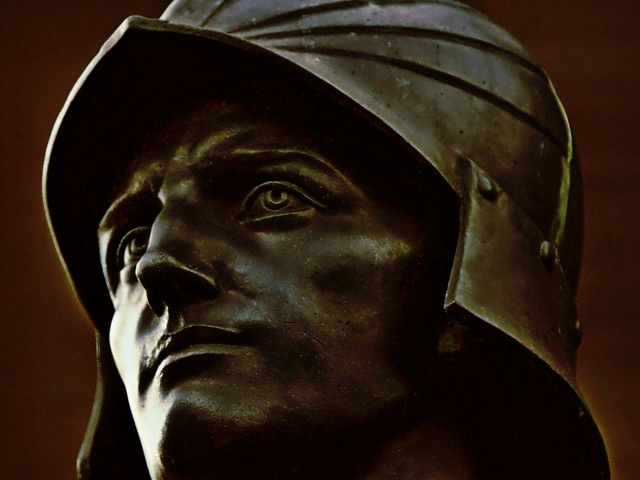 A closeup of a bronze statue's head