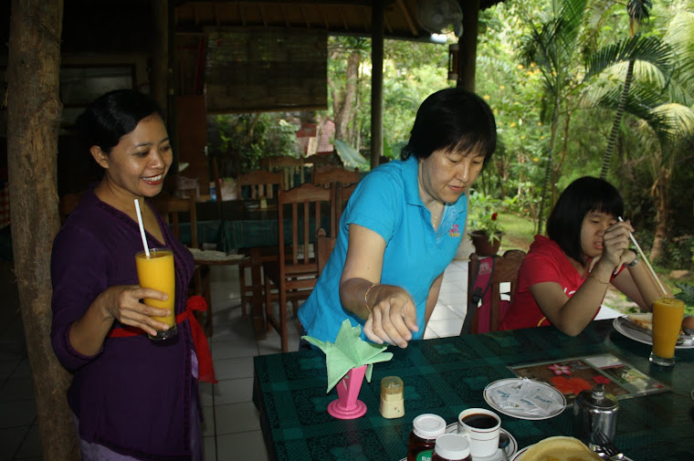 Ibu Ayu serving food to the guest
