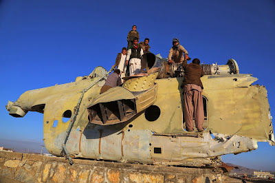 Afghan children play over the wreckage of an old Soviet-era tank in Ghazni on November 15, 2013. Tens of thousands of children in Afghanistan, driven by poverty, work on the streets of the war-torn country's cities and often fall prey to Taliban bombings and other violence, as well as abuse