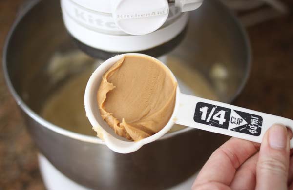Measuring cups of flour and sugar with a peanut butter mixture in