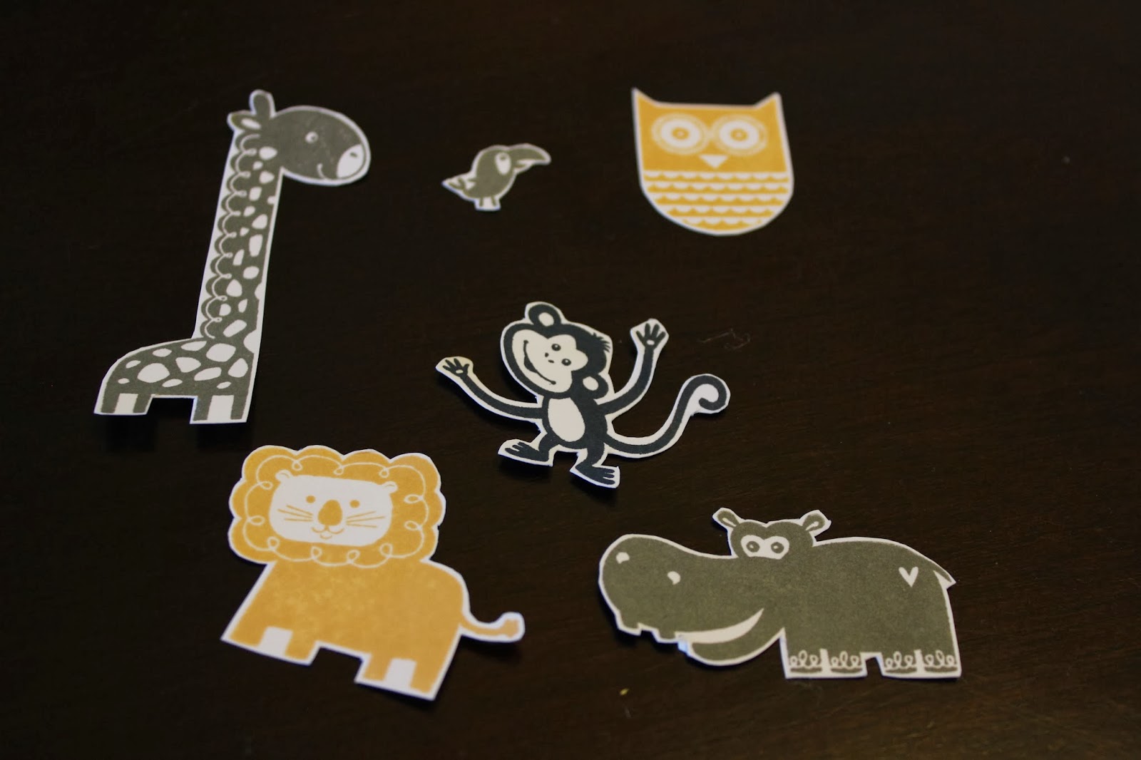 giraffe, tucan bird, owl, monkey, lion and hippo stamped shapes cut out of cardstock