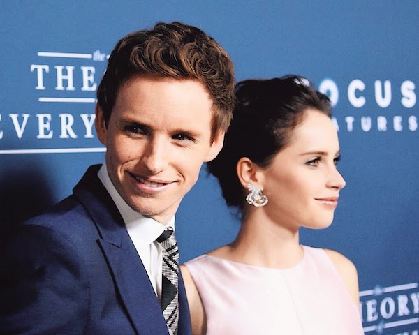 Felicity Jones with Eddie Redmayne in Alexander McQueen Pre AW14 blue one-button suit with McQueen shoulder and silk check tie to attend the premiere of ‘The Theory of Everything’ in Los Angeles, on Tuesday 28th October 2014