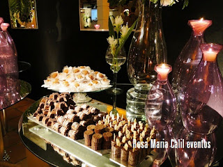 doces, vidros roxos com velas, chocolate, bandeja de prata, parede preta com espelhos