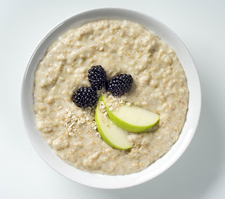 bowl of oatmeal with fresh berries and apples