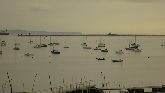 Boats mored on still water in Portland Harbour, Dorset, England