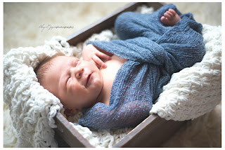 Baby photo with newborn in box wrapped with blankets smiling