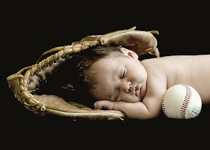 Newborn baby in a baseball glove
