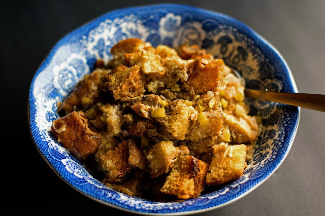 The finished stuffing in a bowl with a serving spoon in it. 