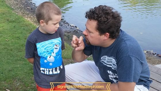 Daddy signs SNAKE while Mr. I. watches next to the pond