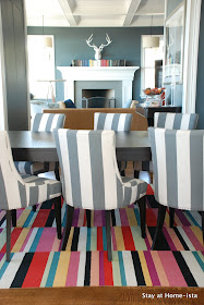 charcoal grey dining room with bright rug and diy art