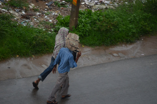 kids with school bag on head running in Monsoon