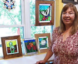 Alice Sahagian with a display of some of her glass art including one of the popular fiddlehead pieces. 