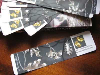 dark promotional bookmarks featuring jewelery design on a wooden table