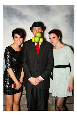a woman in a dark dress, a man in a black suit, and a woman in a light dress pose together for a photo