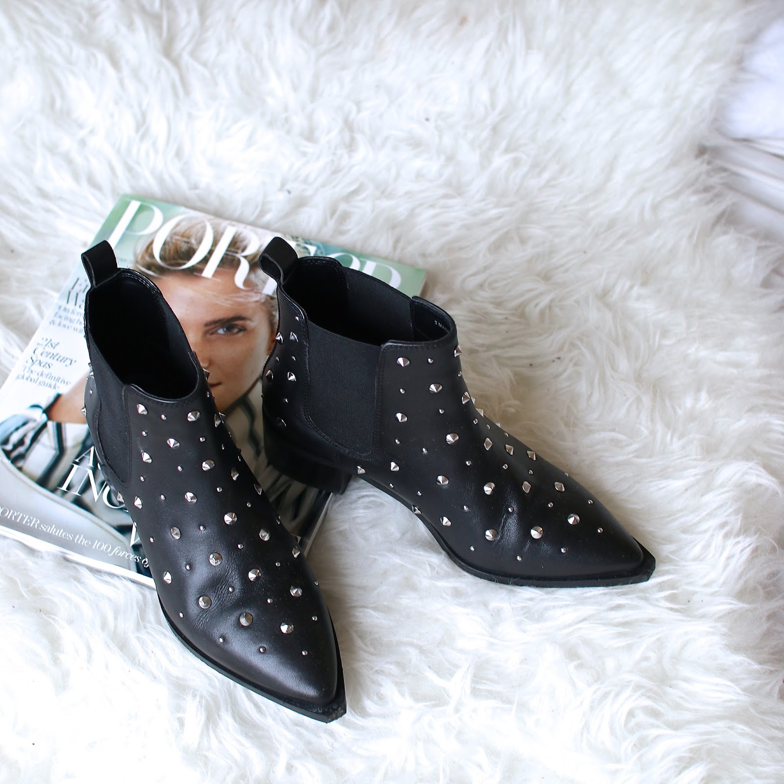 black studded ankle boots sitting on a fur mat