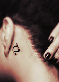 an interesting symbol tattoo behind the ear